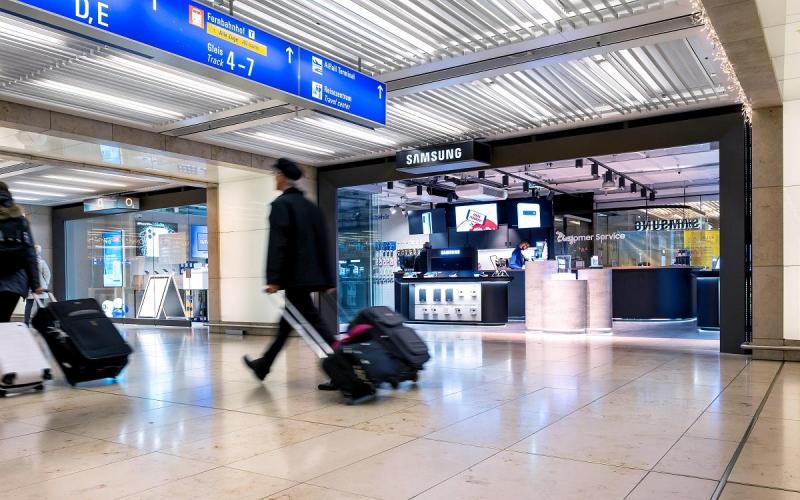 Münch+Münch Samsung Store Flughafen Frankfurt - Passanten mit Reisegepäck vor dem Eingangsbereich
